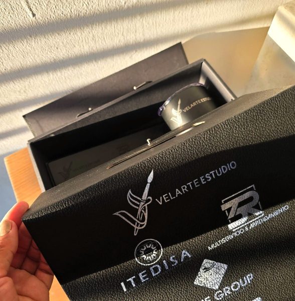 Caja de regalo negra abriéndose, con el kit a la vista